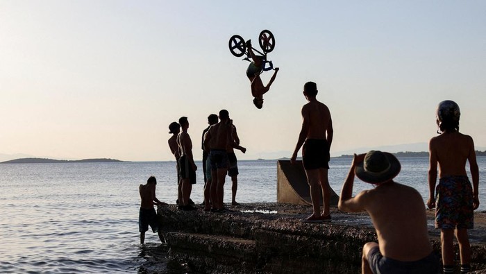 A biker performs tricks at Kavouri beach during a heatwave near Athens, Greece July 24, 2022. REUTERS/Stelios Misinas