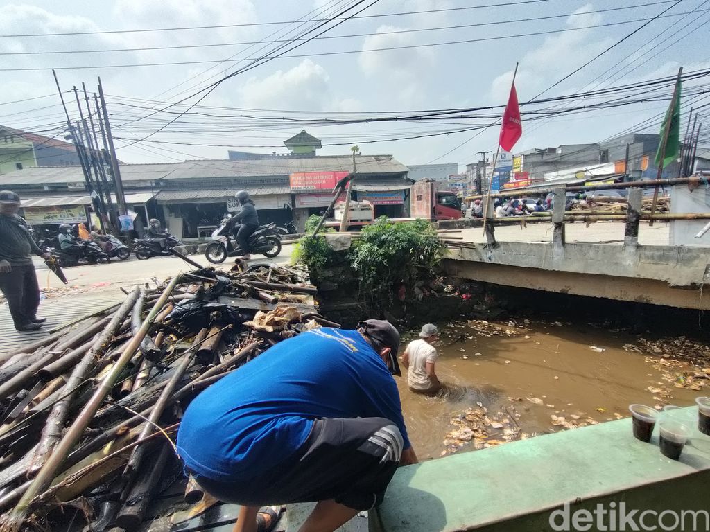 Banjir terjadi di Jalan Raya Pramuka, tepatnya perempatan Mampang, Depok. Lurah mempertanyakan soal sodetan untuk drainase namun tak berfungsi. (Dwi Rahmawati/detikcom)