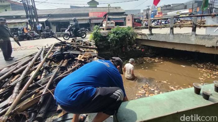 Banjir terjadi di Jalan Raya Pramuka, tepatnya perempatan Mampang, Depok. Lurah mempertanyakan soal sodetan untuk drainase namun tak berfungsi. (Dwi Rahmawati/detikcom)