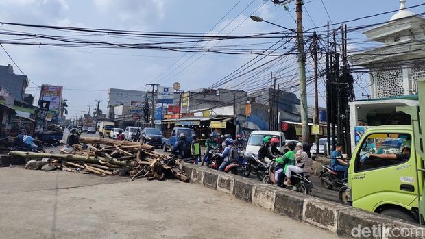 Banjir terjadi di Jalan Raya Pramuka, tepatnya perempatan Mampang, Depok. Lurah mempertanyakan soal sodetan untuk drainase namun tak berfungsi. (Dwi Rahmawati/detikcom)