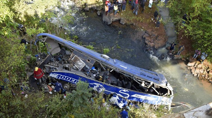 A view of the wreckage of a bus that plunged into Nithi bridge on Sunday, in Tharaka Nithi county Meru, Kenya, Monday, July 25, 2022. Police in Kenya say at least 21 people have died after a bus fell off a bridge and plunged into a river along the highway from the capital, Nairobi, to the central town of Meru. One senior policeman said the bus, traveling from Meru, “must have developed brake failure because it was at a very high speed