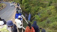 Warga menonton di lokasi jatuhnya bus jatuh ke jurang. Polisi Kenya mengatakan setidaknya 21 orang tewas setelah sebuah bus jatuh dari jembatan ke sungai di sepanjang jalan raya dari ibu kota, Nairobi ke pusat kota Meru.