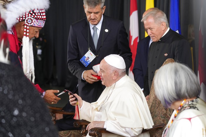 Pope Francis, right, kisses hand to Canadian Indigenous woman as he arrives at Edmonton's International airport, Canada, Sunday, July 24, 2022. Pope Francis begins a weeklong trip to Canada on Sunday to apologize to Indigenous peoples for the abuses committed by Catholic missionaries in the country's notorious residential schools. (AP Photo/Gregorio Borgia)