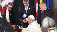 Pemimpin Katolik Roma, Paus Fransiskus menerima jimat dari seorang kepala suku pribumi saat tiba di Bandara Edmonton, Kanada, Minggu (24/7/2022). Selama di Kanada, Paus akan meminta maaf kepada para pribumi Kanada atas kesalahan yang dilakukan para misionaris.