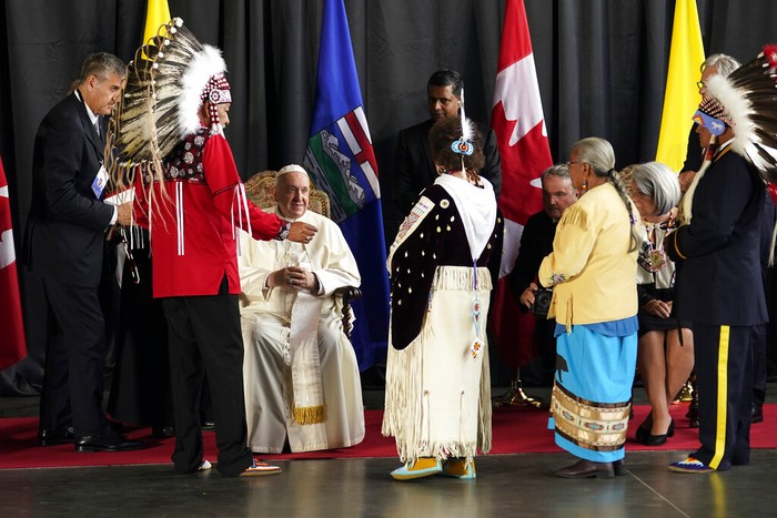 Pope Francis, right, kisses hand to Canadian Indigenous woman as he arrives at Edmonton's International airport, Canada, Sunday, July 24, 2022. Pope Francis begins a weeklong trip to Canada on Sunday to apologize to Indigenous peoples for the abuses committed by Catholic missionaries in the country's notorious residential schools. (AP Photo/Gregorio Borgia)