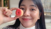 Saat bepergian dengan teman-temannya, suasana alam yang asri dan indah tidak pernah dilewatkan. Bahkan hanya sebuah buah persik saja bisa membuat Amelia Tantono begitu gembira. Foto: Instagram/amelia_tantono