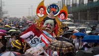 Pengunjukrasa membawa spanduk dan boneka berhambar Marcos Jr. Ia menggantikan Rodrigo Duterte yang sangat populer, yang mendapat kecaman internasional karena perang melawan narkoba yang mematikan.