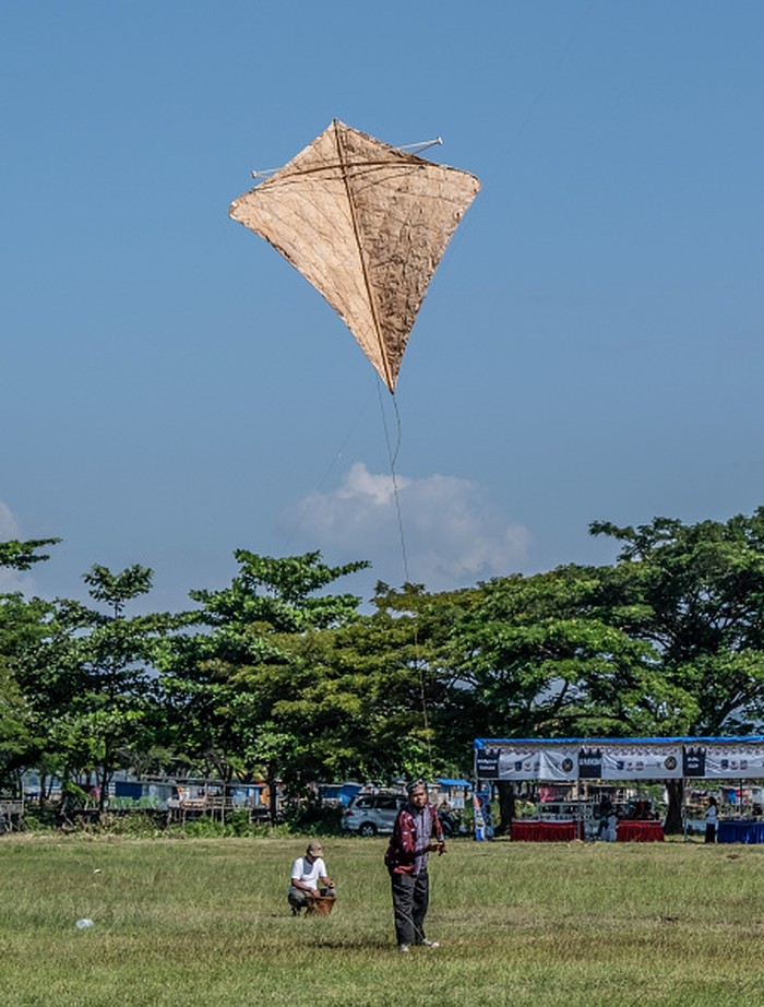 RAHA, SOUTH EAST SULAWESI, INDONESIA - 2022/07/23: An ancient kite owner is getting ready to fly his kite. The Kaghati Kolope or ancient kite is the oldest kite in the world, aged 4 thousand years. Modern recreations of the kite are based on historical discoveries found in one of the caves on the island of Muna, Southeast Sulawesi. All the constituent parts of this ancient-style kite are composed of materials derived from nature with the main component being kolope leaves. (Photo by Andry Denisah/SOPA Images/LightRocket via Getty Images)