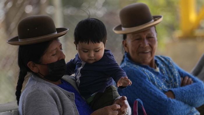 A baby holds his gold medal after winning the baby crawling competition in the Mallasa neighborhood of La Paz, Bolivia, Sunday, July 24, 2022. A dozen babies took part in the competition with a carpet to protect their knees, as moms, dads and grandparents encouraged them. (AP Photo/Juan Karita)