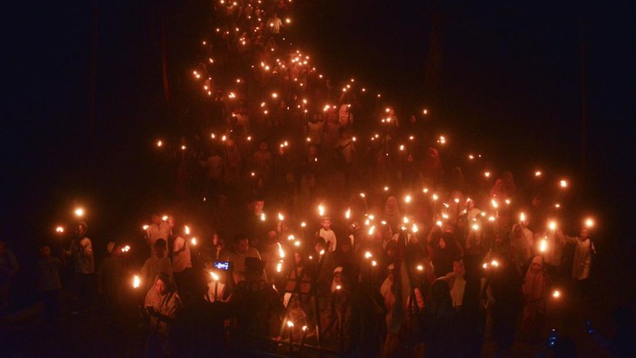 Arak-arakan warga membawa obor saat pawai obor di perkampungan adat Nagari Sijunjung, Kabupaten Sijunjung, Sumatera Barat, Minggu (24/7/2022) malam. Pawai 1.000 obor tersebut digelar sebagai persiapan prosesi Bakaua adat (tolak bala) yang akan digelar pada Senin (25/7/2022). ANTARA FOTO/Iggoy el Fitra/nym.