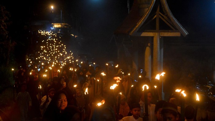 Arak-arakan warga membawa obor saat pawai obor di perkampungan adat Nagari Sijunjung, Kabupaten Sijunjung, Sumatera Barat, Minggu (24/7/2022) malam. Pawai 1.000 obor tersebut digelar sebagai persiapan prosesi Bakaua adat (tolak bala) yang akan digelar pada Senin (25/7/2022). ANTARA FOTO/Iggoy el Fitra/nym.