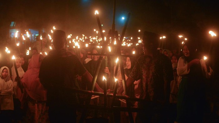 Arak-arakan warga membawa obor saat pawai obor di perkampungan adat Nagari Sijunjung, Kabupaten Sijunjung, Sumatera Barat, Minggu (24/7/2022) malam. Pawai 1.000 obor tersebut digelar sebagai persiapan prosesi Bakaua adat (tolak bala) yang akan digelar pada Senin (25/7/2022). ANTARA FOTO/Iggoy el Fitra/nym.