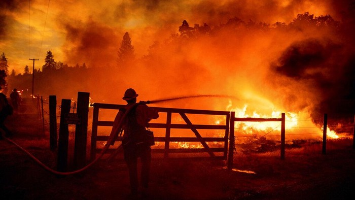 Firefighters work to keep the Oak Fire from reaching a home in the Jerseydale community of Mariposa County, Calif., on Saturday, July 23, 2022. (AP Photo/Noah Berger)
