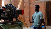 Seniman Ghana, Ibrahim Mahama (35), memeriksa mesin baling-baling pesawat di fasilitas studionya di Tamale, Ghana, Jumat, (15/7/2022). Mahama membeli pesawat bekas untuk menambah koleksi di Red Clay Studio. Studio tersebut merupakan sebuah kompleks yang berfungsi sebagai pusat pendidikan terbuka bagi warga Jenakpeng, Ghana.