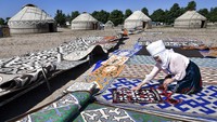 Seorang wanita Kirgistan meletakkan karpet di depan yurt, rumah tradisional Kirgistan selama festival Ak-Moor Fest Etno di Ornok, sebuah desa resor di pantai utara Danau Issyk-Kul, 207 kilometer (129 mil) timur Bishkek, Kirgistan , Sabtu, (23/7/2022).