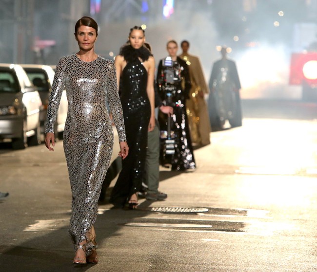Supermodel tahun 90-an, Helena Christensen, ikut bergabung bersama para top model lainnya untuk melenggang di jalanan New York mengenakan busana Michael Kors. Foto: James Devaney/GC Images