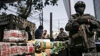 Petugas berseragam dan bersenjata menjaga barang bukti selama acara. Barang haram tersebut disita dari 15 kasus tindak pidana narkotika periode Mei hingga Juli 2022.
