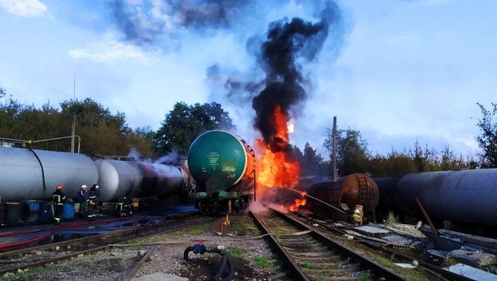Firefighters gather near tank cars as they work to extinguish a fire at an oil depot in the Budyonnovsky district of Donetsk, Ukraine, in this handout image released by the self-proclaimed Donetsk People's Republic's emergencies ministry July 26, 2022. Press Service of Emergencies Ministry of Donetsk People's Republic/Handout via REUTERS ATTENTION EDITORS - THIS IMAGE HAS BEEN SUPPLIED BY A THIRD PARTY. NO RESALES. NO ARCHIVES. MANDATORY CREDIT.