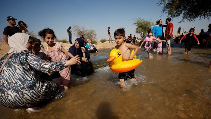 Palestinians and Israel settlers cool off during a heat wave, in al-Oja springs near Jericho in the Israeli-Occupied West Bank July 22, 2022. REUTERS/Mohamad Torokman