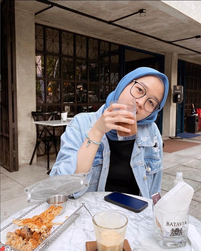Gaya hijabnya sehari-hari, Alca memilih hijab segi empat polos sebagai andalan. Ia kerap membentuk hijab diikat ke belakang dengan rapi. Seperti sedang berada hangout ini, ia memakai hijab segi empat voal dipadu denim leather jacket. Foto: Dok. Instagram @alcaoctvn.