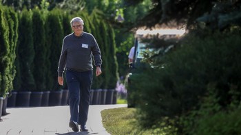 Bill Gates tampak berjalan di antara pepohonan yang asri. Foto: Getty Images