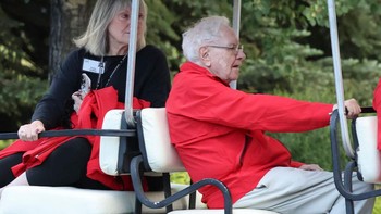 Investor kenamaan Warren Buffet datang memakai kendaraan golf. Foto: Getty Images