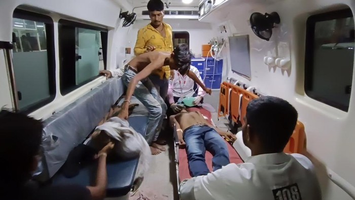 People wait to be carried into a hospital for treatment after falling sick from consuming spurious liquor in Botad, India, Tuesday, July 26, 2022. At least 21 people have died and another 30 fallen sick from drinking spurious liquor in Indias western state of Gujarat, officials said Tuesday. Senior government official Mukesh Parmar said the deaths occurred in Ahmedabad and Botad districts of the state, where manufacturing, sale and consumption of liquor are prohibited. (AP Photo)