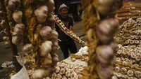 Penjual menawarkan potongan bawang putih kepada pelanggan di Pasar Vitoria, Spanyol utara, Senin (25/7/2022).