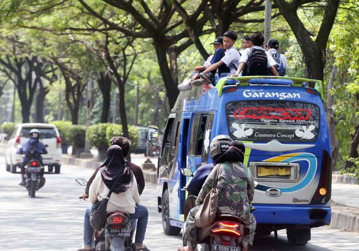 Sejumlah pelajar sekolah menengah pertama (SMP) menumpang di atas atap mobil angkutan umum melintas di Jalan Marsekal Surya Dharma Neglasari, Tangerang, Banten, Selasa (26/7/2022). Aksi tersebut membahayakan keselamatan diri sendiri dan orang lain, serta dapat memicu tawuran antarpelajar yang kerap terjadi saat jam pulang sekolah. ANTARA FOTO/Muhammad Iqbal/rwa.