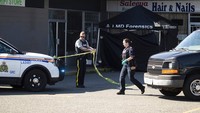 Petugas RCMP memindahkan pita polisi di dekat tenda yang menutupi tubuh di salah satu dari tiga lokasi yang diselidiki sehubungan dengan beberapa penembakan di Langley, British Columbia, Senin, (25/7/2022). Peristiwa ini terjadi di Langley, sekitar 900 km sebelah selatan Ibu Kota Ottawa.