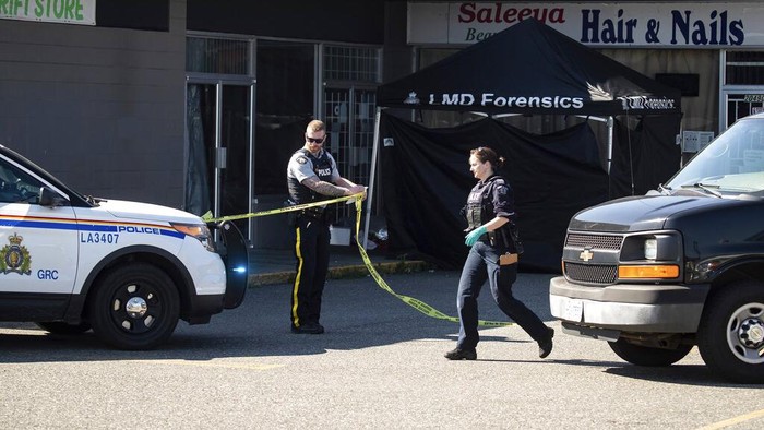Penembakan di Kanada, 2 Orang Tewas A police officer stands near a RCMP vehicle with bullet holes in the windshield and driver's side window at the scene of a shooting in Langley, British Columbia, Monday, July 25, 2022. (Darryl Dyck/The Canadian Press via AP)
