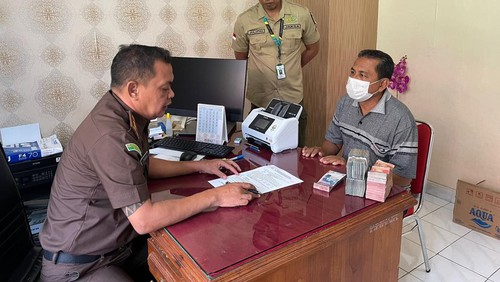 Pengurus LPD Adat Anturan Berinisial NW Saat Sedang Mengembalikan Uang Reward Kaplingan LPD Adat Anturan, Selasa (26/7/2022).