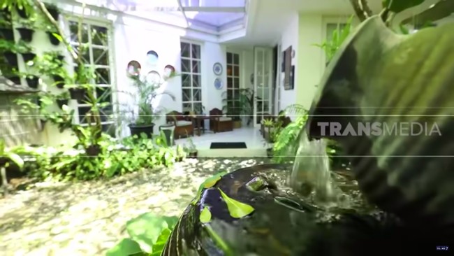 Rumah penyanyi Yuni Shara bak oasis di tengah kegersangan ibukota. Betapa tidak, pohon rindang dan tumbuhan rimbun mengelilingi bangunan hunian bergaya american-classic itu. (Foto: YouTube TRANS7 OFFICIAL)
