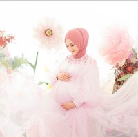 Penampilan Ria Ricis yang berkesan dreamy dengan gaun tulle warna pink serta latar belakang bunga-bunga nan cantik. Foto: Instagram/@fdphotography90 @teukuryantr
