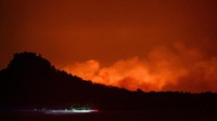 Api panas membuat langit memerah. Diduga kebakaran terjadi karena kelalaian manusia.  