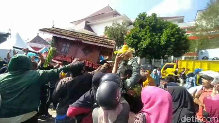 Warga berebut isi jampana.