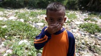 Anak kecil menutup hidung lantaran aroma busuk yang tercium dari lautan sampah itu.