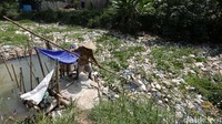 Warga melihat sampah yang menumpuk di Kali Cikarang, Desa Sakaringin, Sakawangi, Kabupaten Bekasi, Jawa Barat, Rabu (27/7/2022).