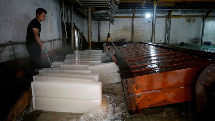China Panas Banget, Pabrik Es di Shanghai Kebanjiran Pesanan Employees work on the production line of ice blocks at Shanghai Yuhu ice-making factory, amid a heatwave warning in Shanghai, China July 26, 2022. REUTERS/Aly Song