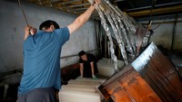 Pabrik pembuat es balok di pinggiran kota Shanghai tengah sibuk karena kebanjiran pesanan.