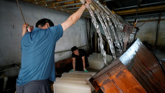 Employees work on the production line of ice blocks at Shanghai Yuhu ice-making factory, amid a heatwave warning in Shanghai, China July 26, 2022. REUTERS/Aly Song