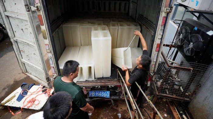 Employees work on the production line of ice blocks at Shanghai Yuhu ice-making factory, amid a heatwave warning in Shanghai, China July 26, 2022. REUTERS/Aly Song