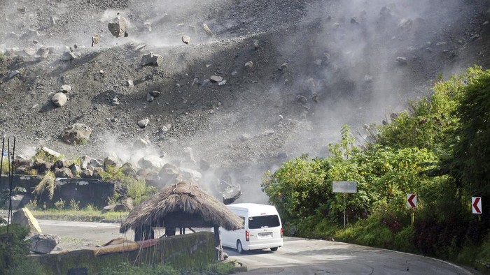 A damaged truck lies beside boulders after it fell along a road during an earthquake in Bauko, Mountain Province, Philippines on Wednesday July 27, 2022. A strong earthquake left some people dead and injured dozens in the northern Philippines on Wednesday, where the temblor set off small landslides and damaged buildings and churches and prompted terrified crowds and hospital patients in the capital to rush outdoors. One passenger was injured after a boulder hit the vehicle. (AP Photo/Harley Palangchao)