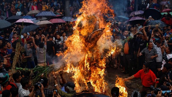 Warga bersorak saat Patung Ghantakarna terbakar selama festival di Bhaktapur, Nepal, Selasa, (26/7/2022).