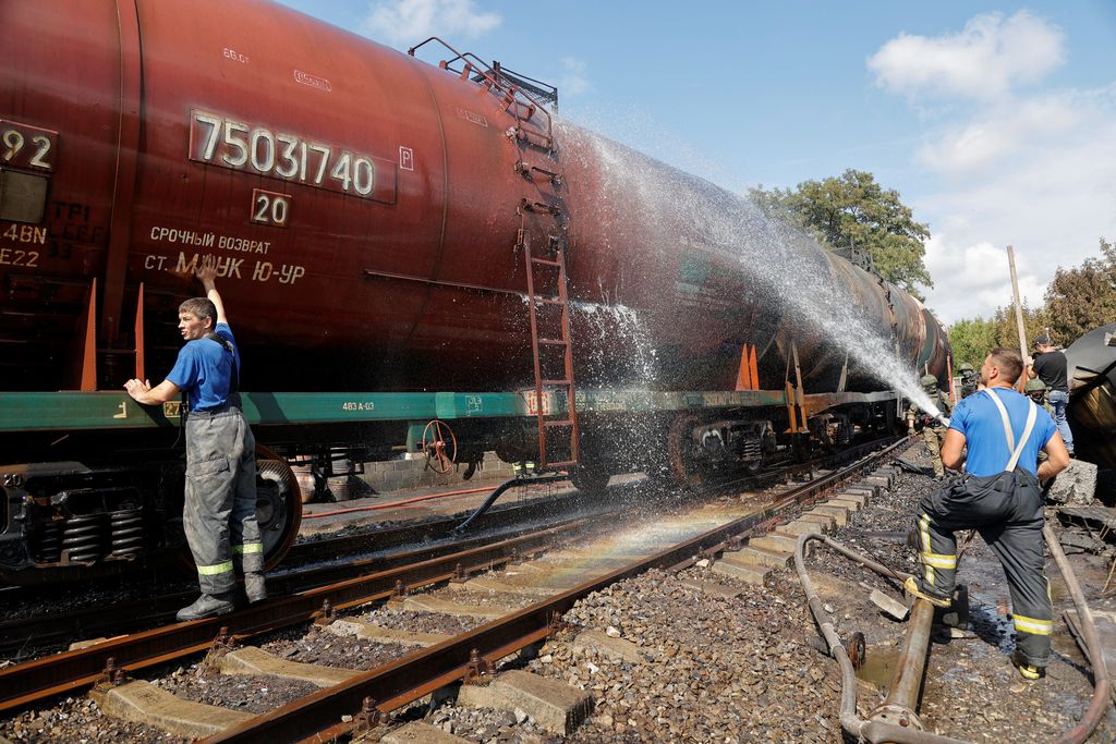 Penyelidik militer Rusia bekerja di lokasi kebakaran di depot minyak di distrik Budyonnovsky di Donetsk, Ukraina, 26 Juli 2022. (REUTERS/STRINGER)