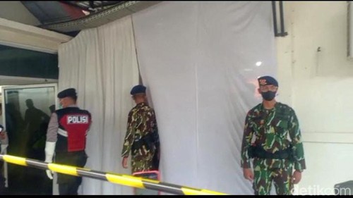 Polisi berpakaian dinas berjaga di depan kamar jenazah tempat autopsi ulang Brigadir J (foto: Tangkapan layar)