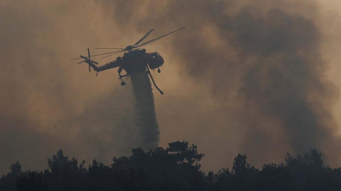 A firefighting helicopter drops water during a wildfire in the Dadia National Park, in Evros, Greece, July 25, 2022. REUTERS/Alexandros Avramidis
