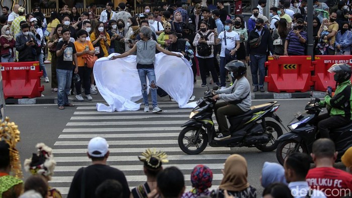 Sejumlah warga beraktivitas di Zebra Cross, Dukuh Atas, Jakarta, Rabu (27/7/2022). Lokasi yang dikenal sebagai Citayam Fashion Week (CFW) ini tetap ramai kala jam pulang kerja.