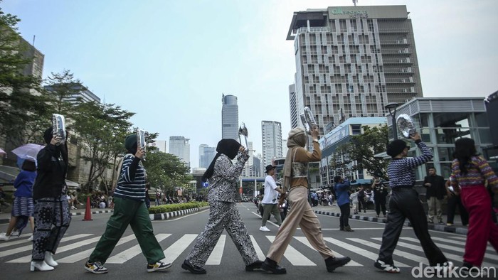 Sejumlah warga beraktivitas di Zebra Cross, Dukuh Atas, Jakarta, Rabu (27/7/2022). Lokasi yang dikenal sebagai Citayam Fashion Week (CFW) ini tetap ramai kala jam pulang kerja.