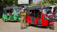 Petugas polisi mengatur lalu lintas di sebuah pompa bensin. Kendaraan roda tiga masih menjadi salah satu alat transportasi publik utama di Kolombo.